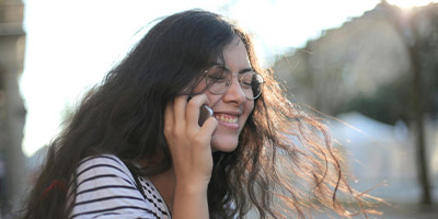 young woman smiling while talking on a phone
