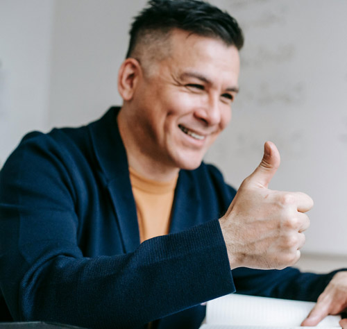 smiling man giving thumbs up in an office